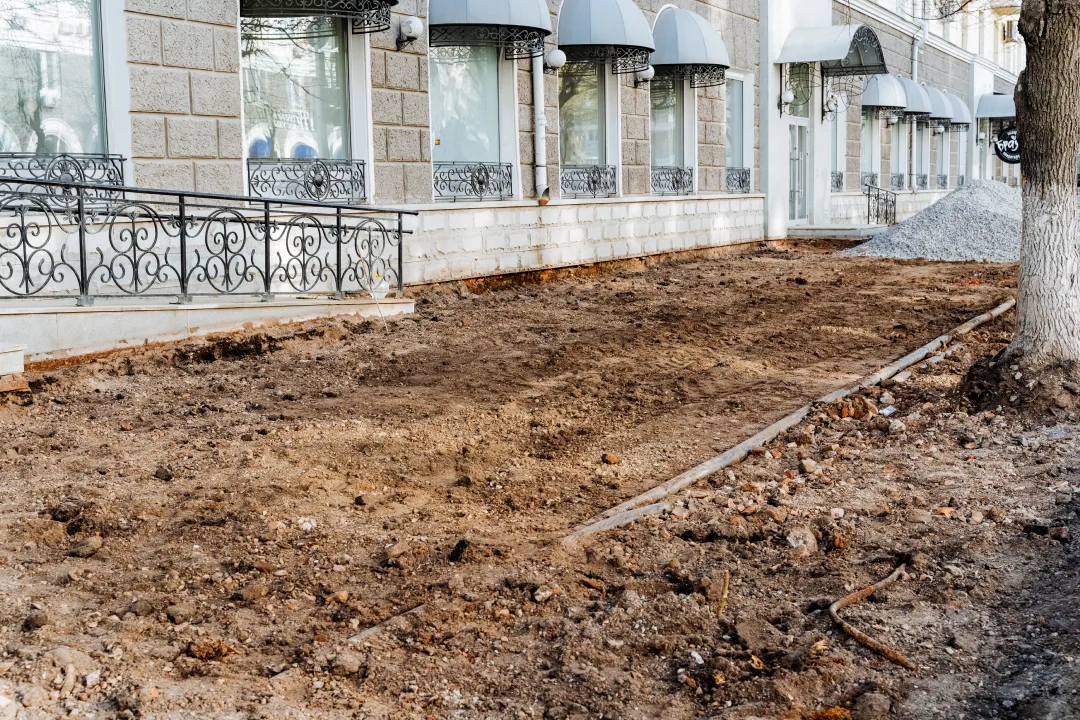 a mound of dirt sits by the building awaiting landscaping photo 1